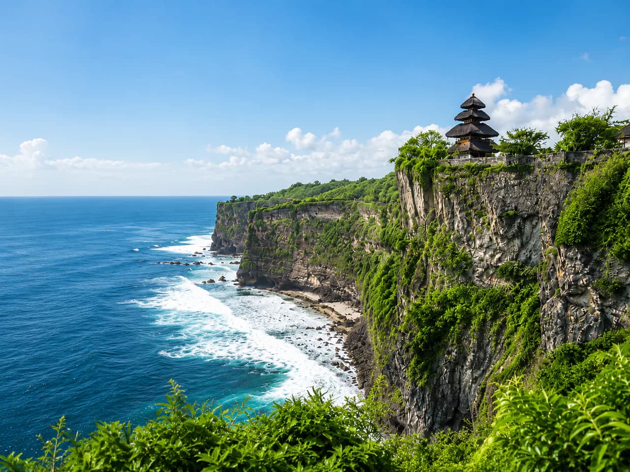 Pura di tebing Uluwatu dengan pemandangan laut biru di bawah langit cerah